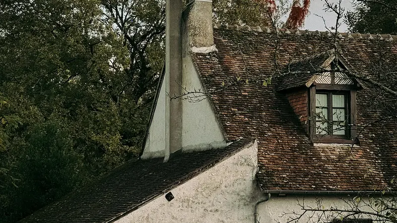 Toit de tuiles anciennes et lucarne d'une maison de campagne française