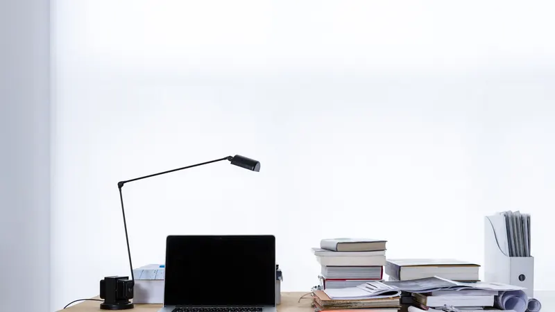 Laptop and stack of books on a desk